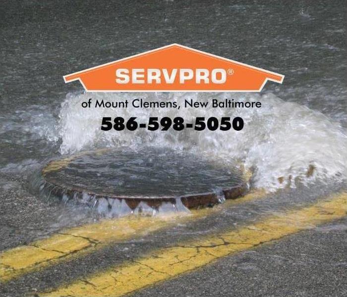 man hole cover in street with water coming out 